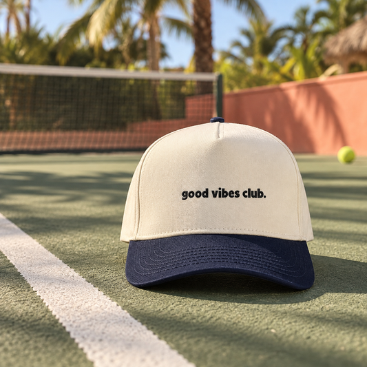 Ronny Cap with a Natural crown, Midnight brim and good vibes club. wordmark on a tennis court.