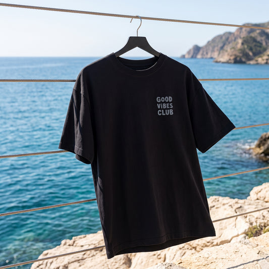 Black Oversized Club Tee hanging beside the sea.